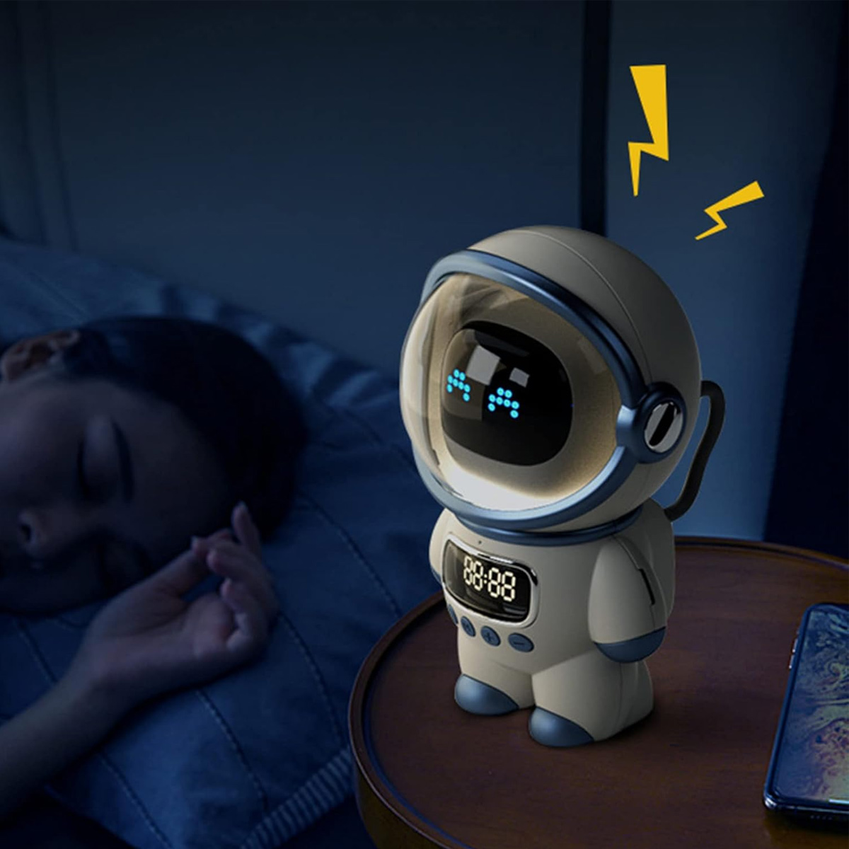 Ein astronautenförmiger Wecker auf einem Nachttisch. Im Hintergrund schläft eine Person. Über der Uhr erscheinen Blitze.