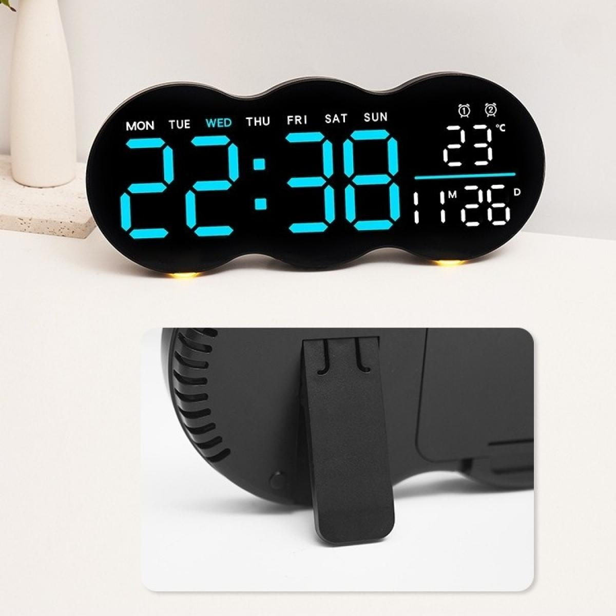 Schwarzer digitaler Wecker mit der Anzeige 22:38, 23°C und Datum. Die Uhr hat einen Ständer auf weißem Untergrund.
