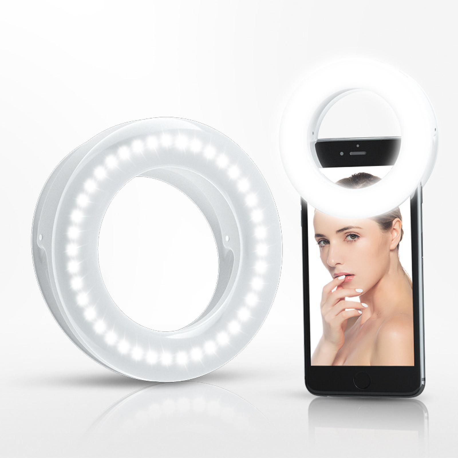 Ein Ringlicht umgibt ein Smartphone, das eine Frau zeigt. Ein zweites Ringlicht befindet sich links.