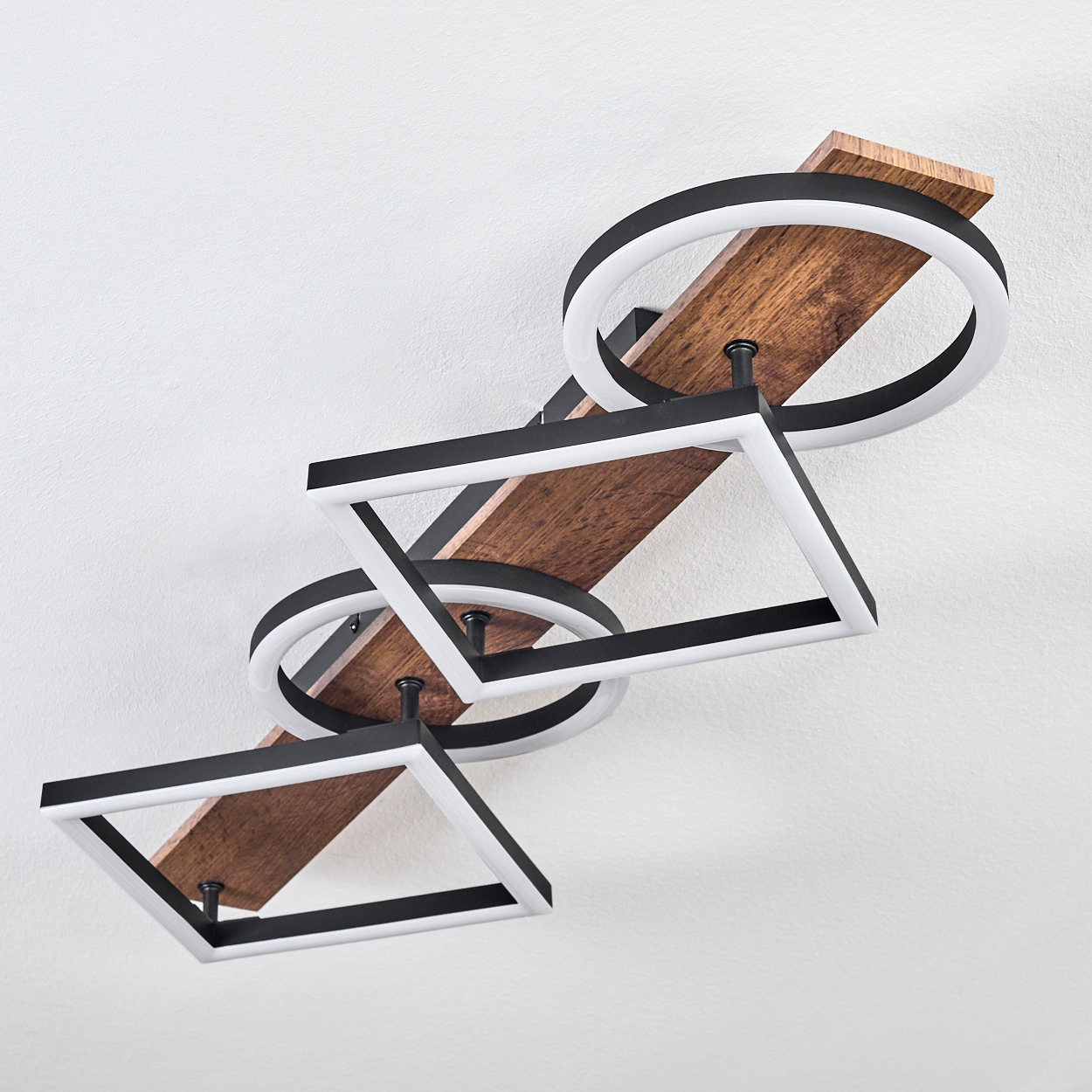 Deckenleuchte mit Holzplanken und geometrischen schwarz-weißen Lichtringen und -quadraten, montiert an einer weißen Decke.