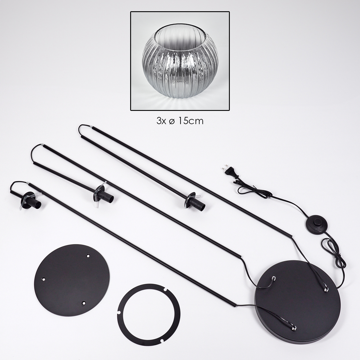 Zerlegte Lampenteile. Enthält Glasschale, schwarze Metallstäbe, Sockel und Netzkabel. Teile liegen auf weißem Untergrund.