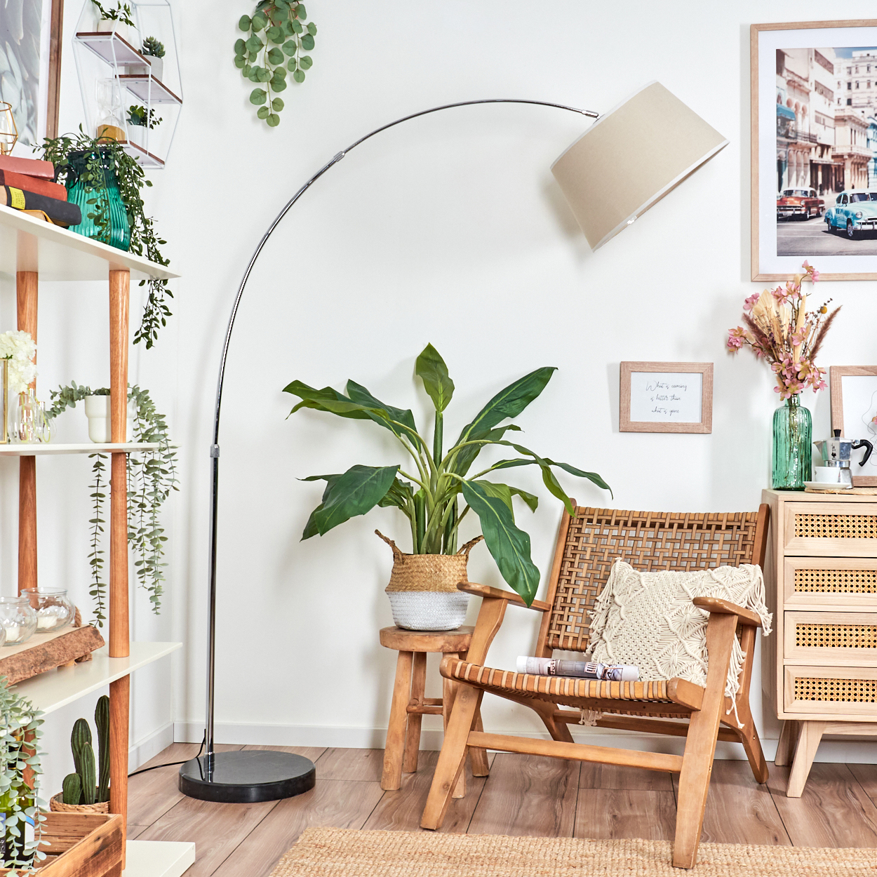 Ein Raum mit Holzstuhl, Pflanzen, Lampe und Schrank. Ein Bild von Autos hängt an der Wand.
