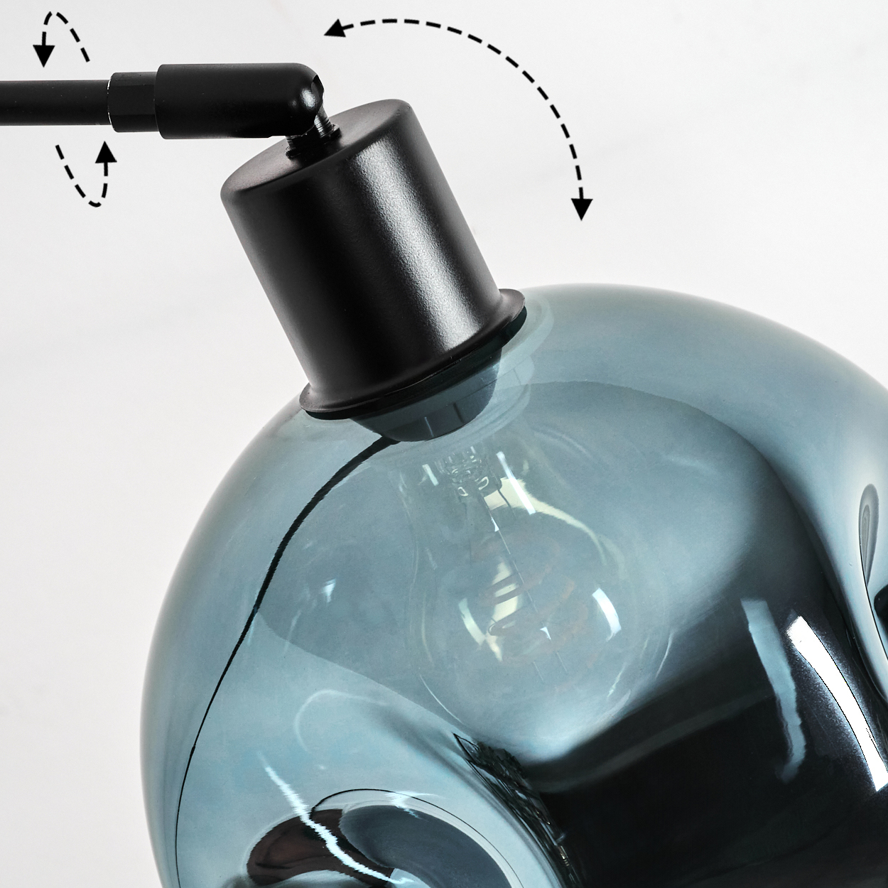 Nahaufnahme einer modernen Lampe. Sie hat einen schwarzen Arm und einen blau getönten Glasschirm mit einer sichtbaren Glühbirne. Gestrichelte Pfeile zeigen Bewegung an.