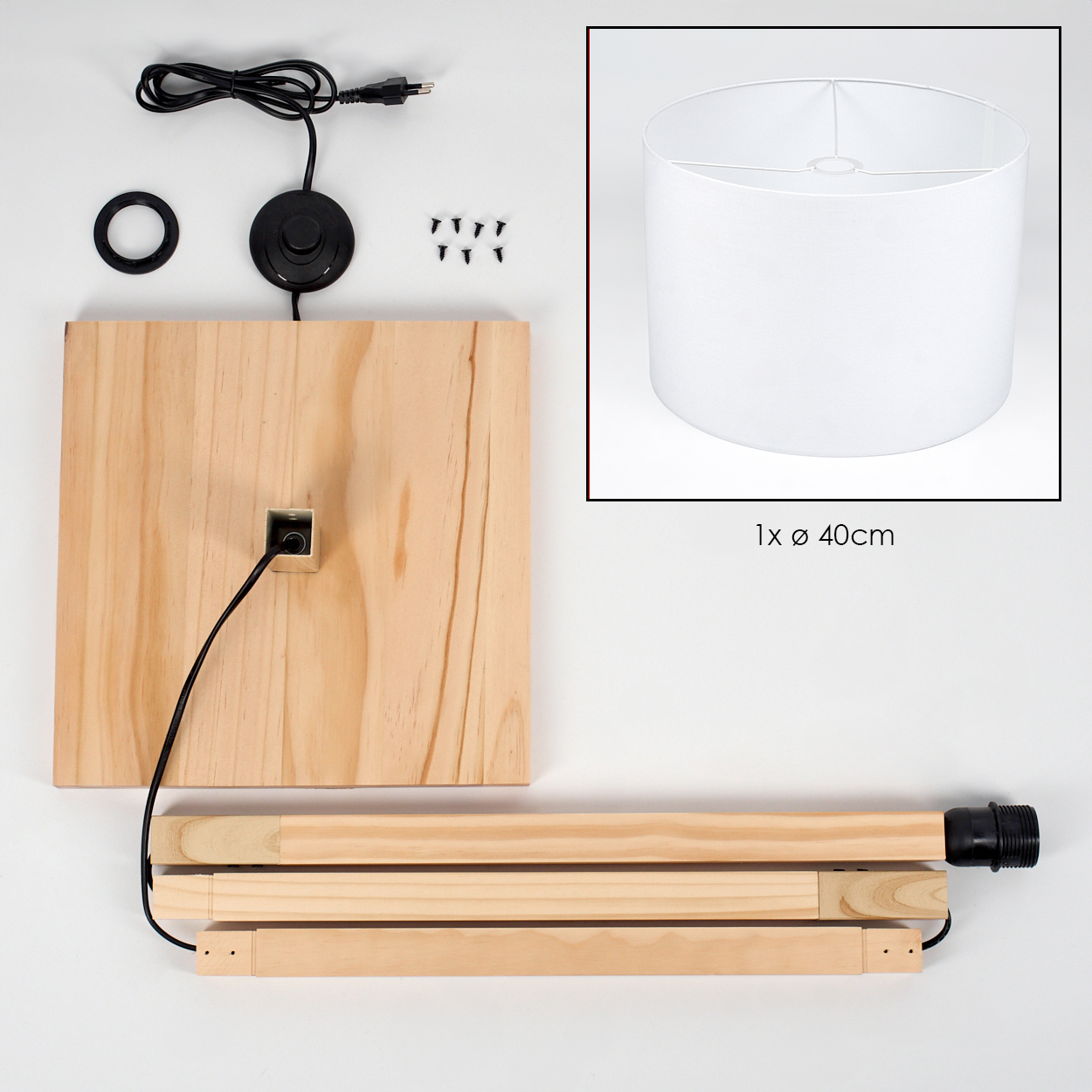 Holzteile einer Lampe, einschließlich Sockel, Schirm und Stiel, auf weißer Oberfläche mit Netzkabel und Schrauben.