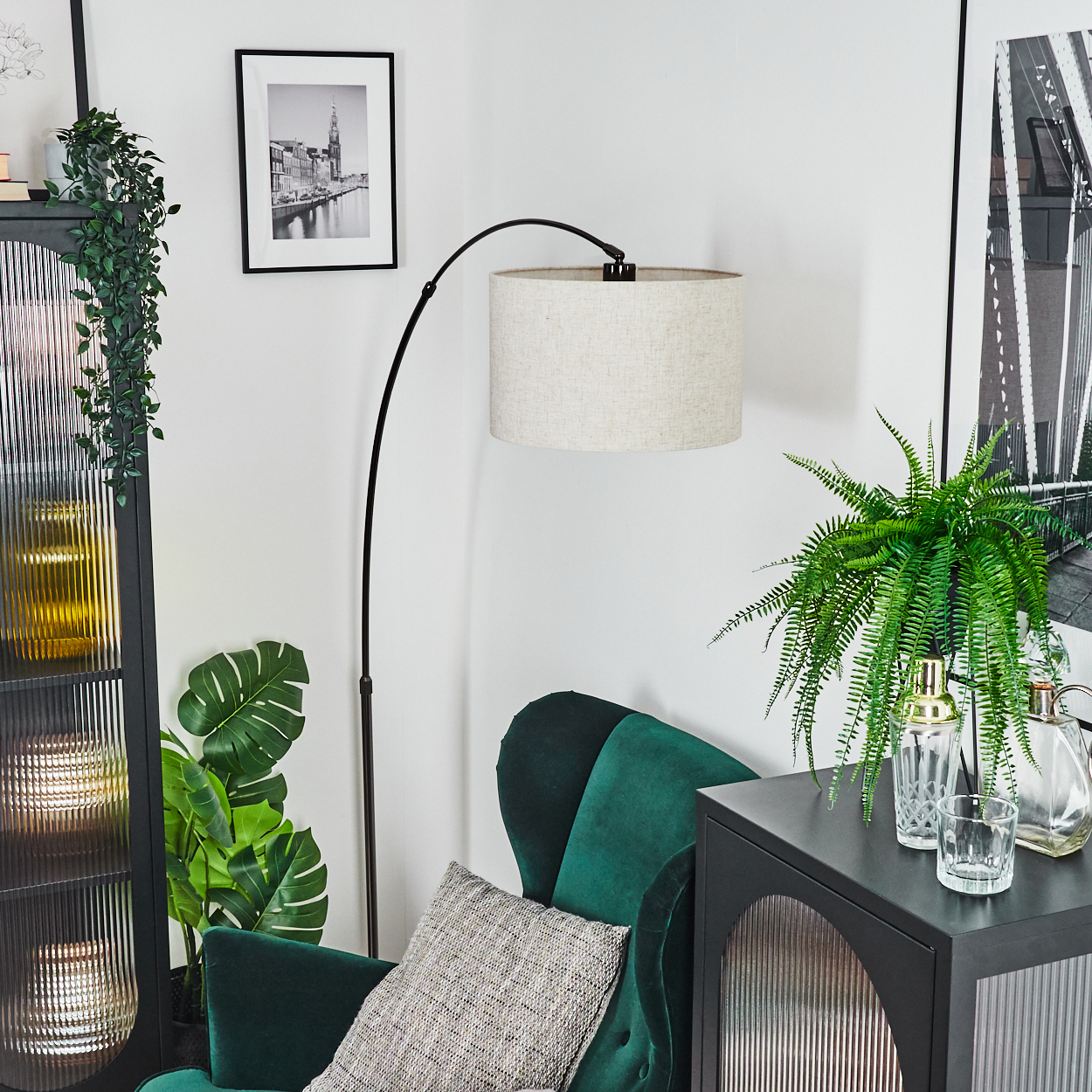 Ecke des Wohnzimmers mit grünem Stuhl, Lampe und Schrank. Ein Schwarz-Weiß-Foto hängt an der Wand.