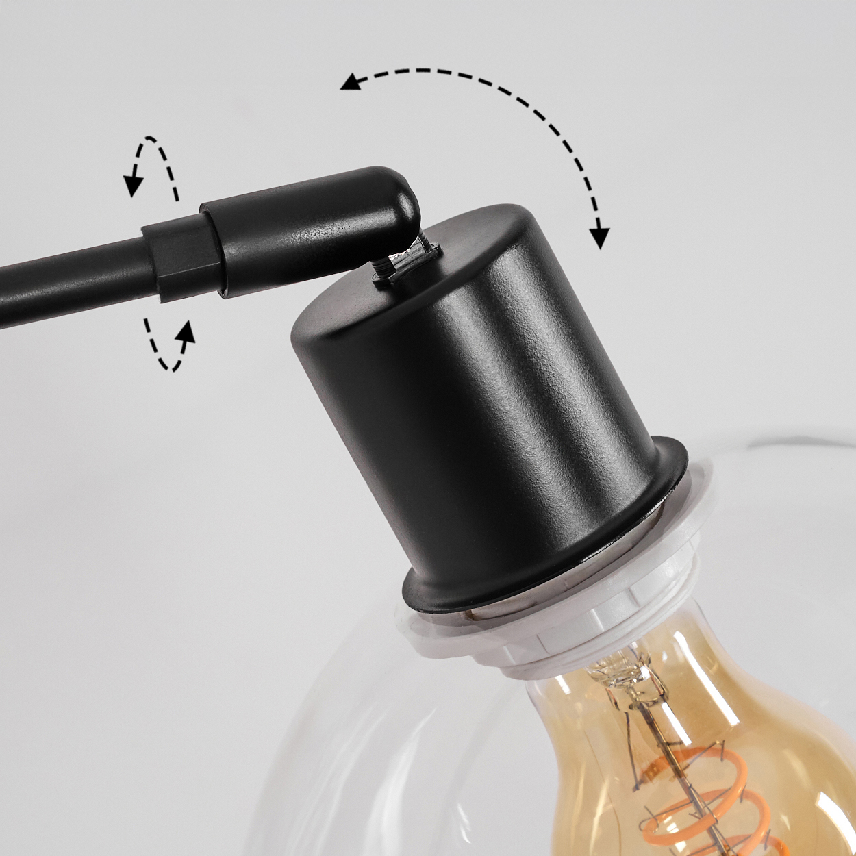 Nahaufnahme einer schwarzen Lampe. Ein schwarzes zylindrisches Teil ist mit einer schwarzen Stange verbunden. Darunter ist eine Glühbirne zu sehen.