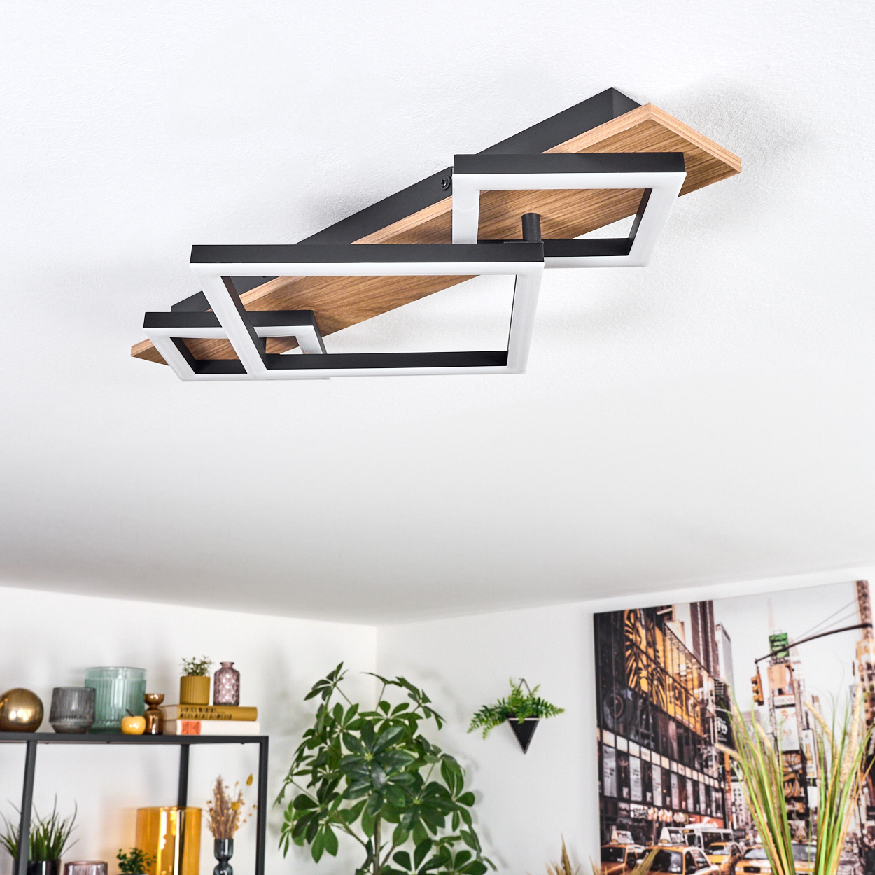 Eine moderne Deckenleuchte mit geometrischen Formen. Darunter ein Raum mit Pflanzen, Regalen mit Dekorationen und einem Stadtbild.