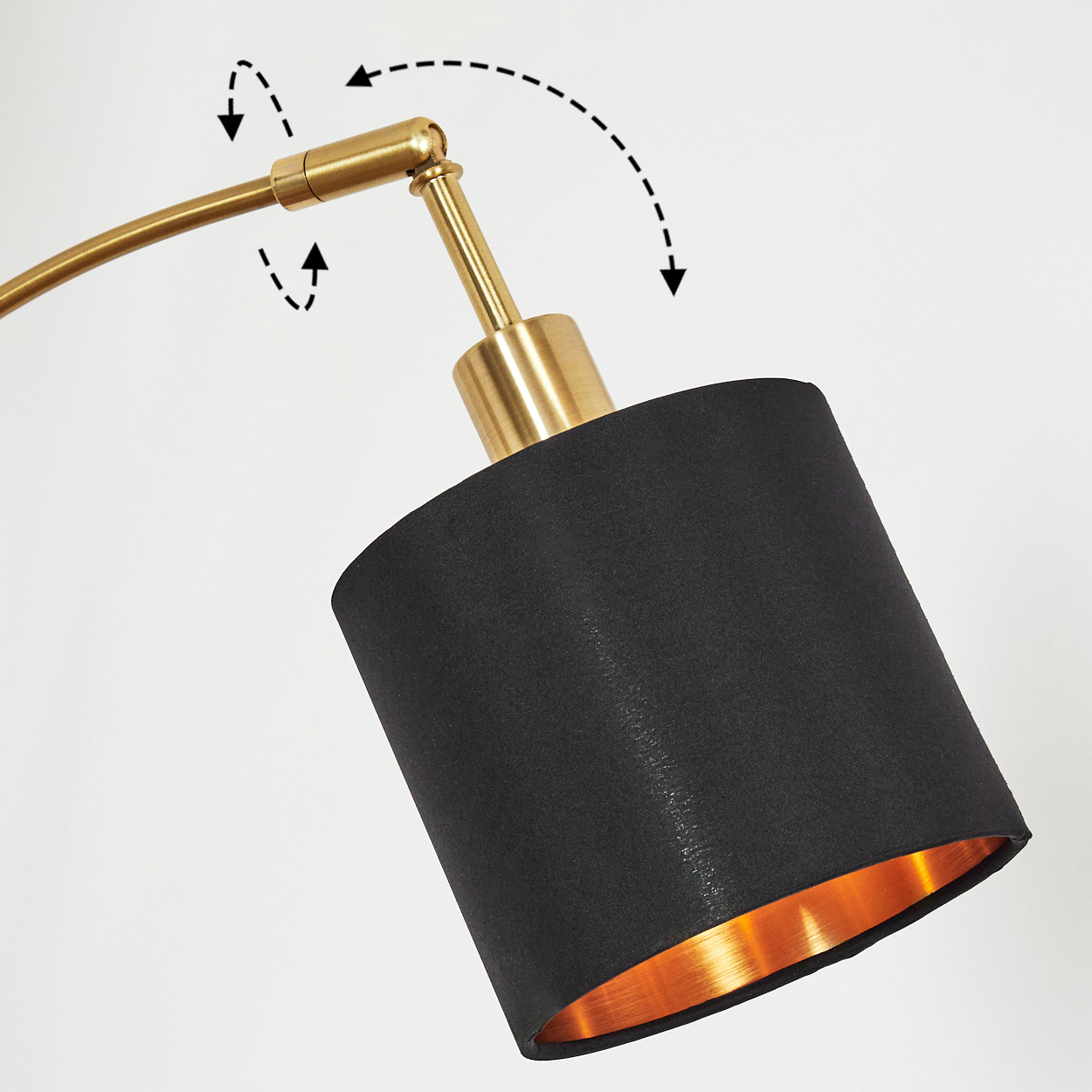 Nahaufnahme einer Lampe. Sie hat einen schwarzen Lampenschirm mit goldener Innenseite und einen Messingarm. Pfeile zeigen die Bewegung an.