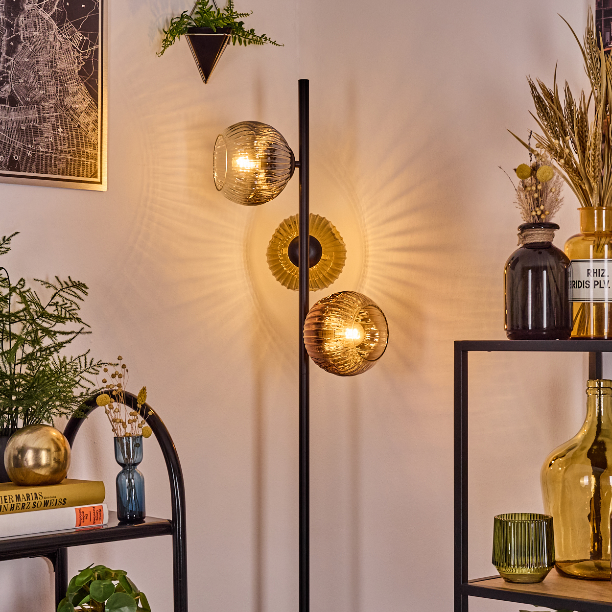 Eine moderne Wohnzimmerecke mit einer stilvollen Lampe, Regalen mit Vasen und einem Kartenbild an der Wand.