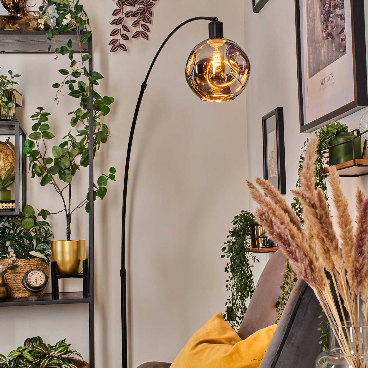 Wohnzimmer-Szene mit Bogenlampe, Pflanzen, Regalen und einem grauen Sofa mit gelben Kissen. Kunstwerk an der Wand.