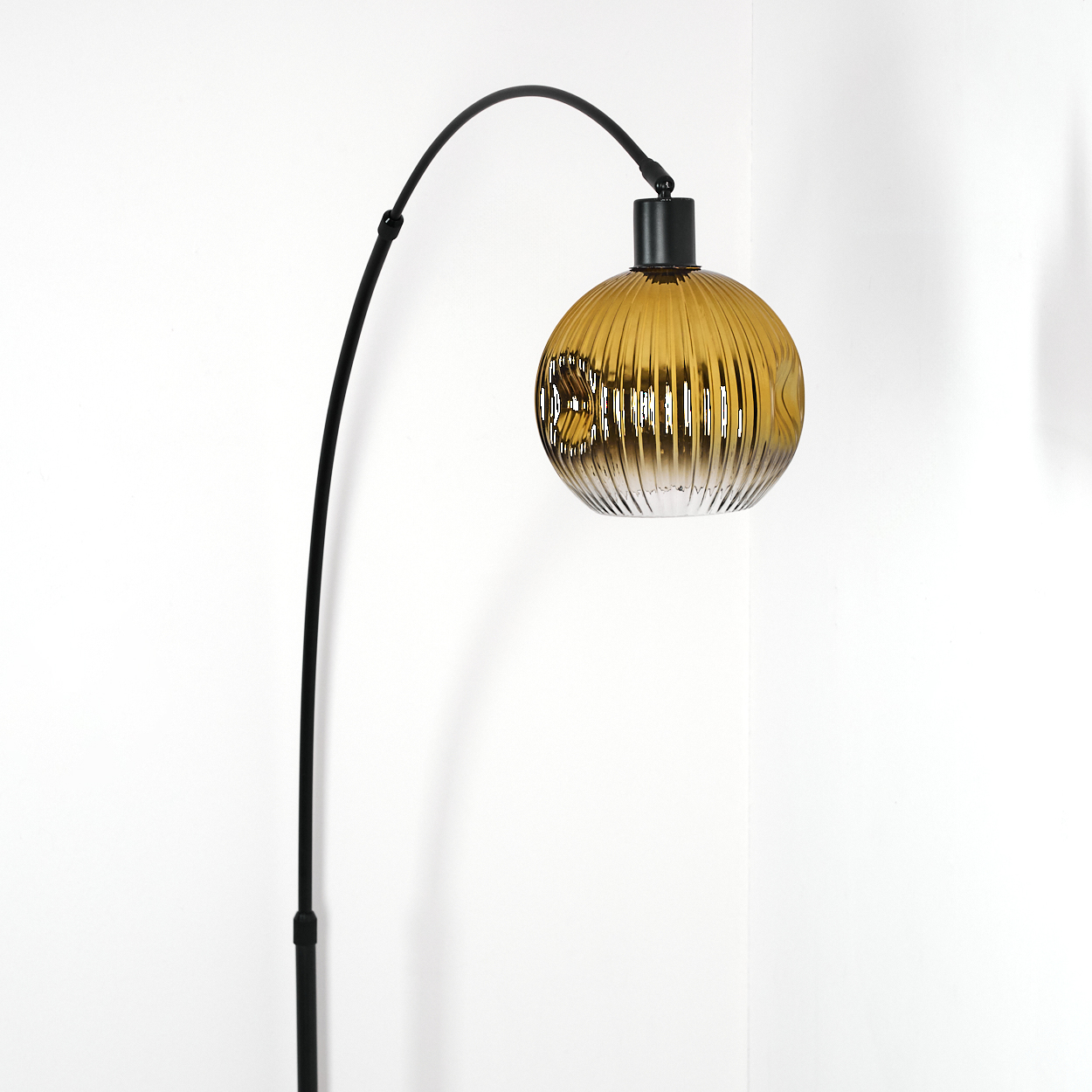 Eine moderne Stehlampe mit schwarzem, gebogenem Arm und einem kugelförmigen, gerippten, bernsteinfarbenen Glasschirm auf weißem Hintergrund.