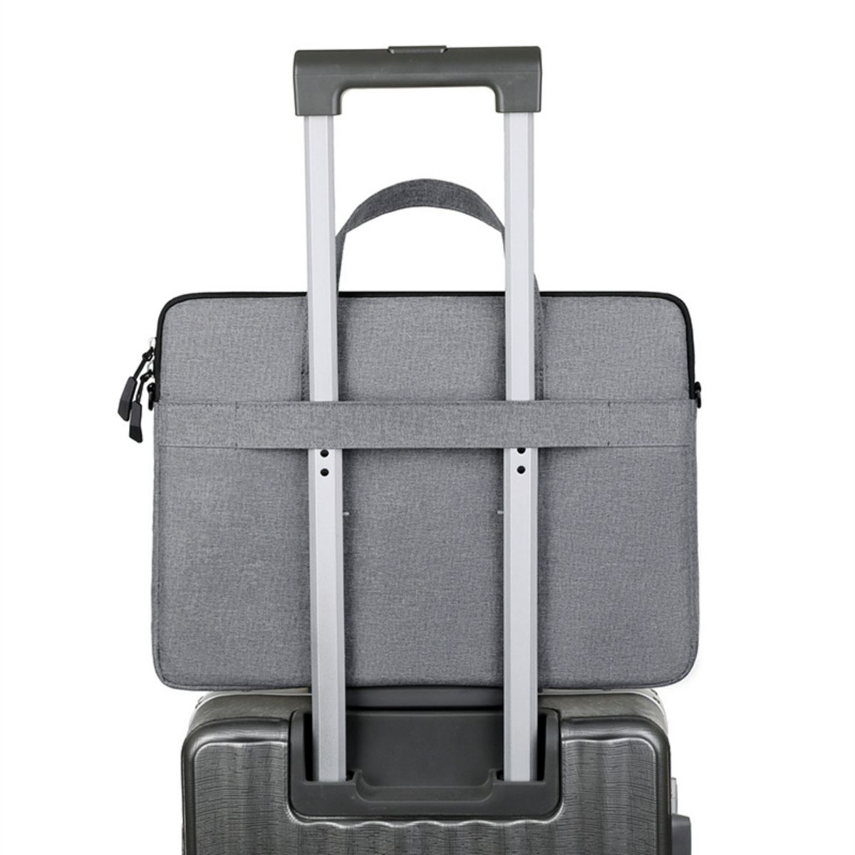 Eine graue Laptoptasche ist an einem Koffergriff befestigt. Die Tasche befindet sich oben auf dem Koffer. Der Griff ist ausgezogen.