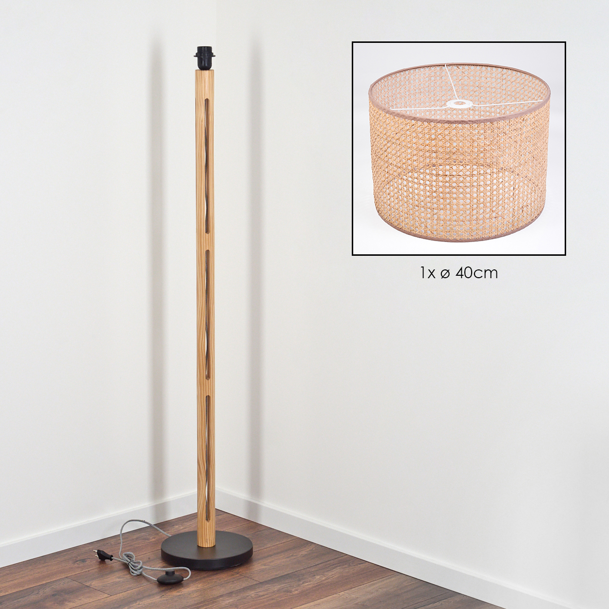 Eine Stehlampe aus Holz mit gewebtem Lampenschirm. Die Lampe ist hoch und schlank, in einer Ecke vor einer weißen Wand.