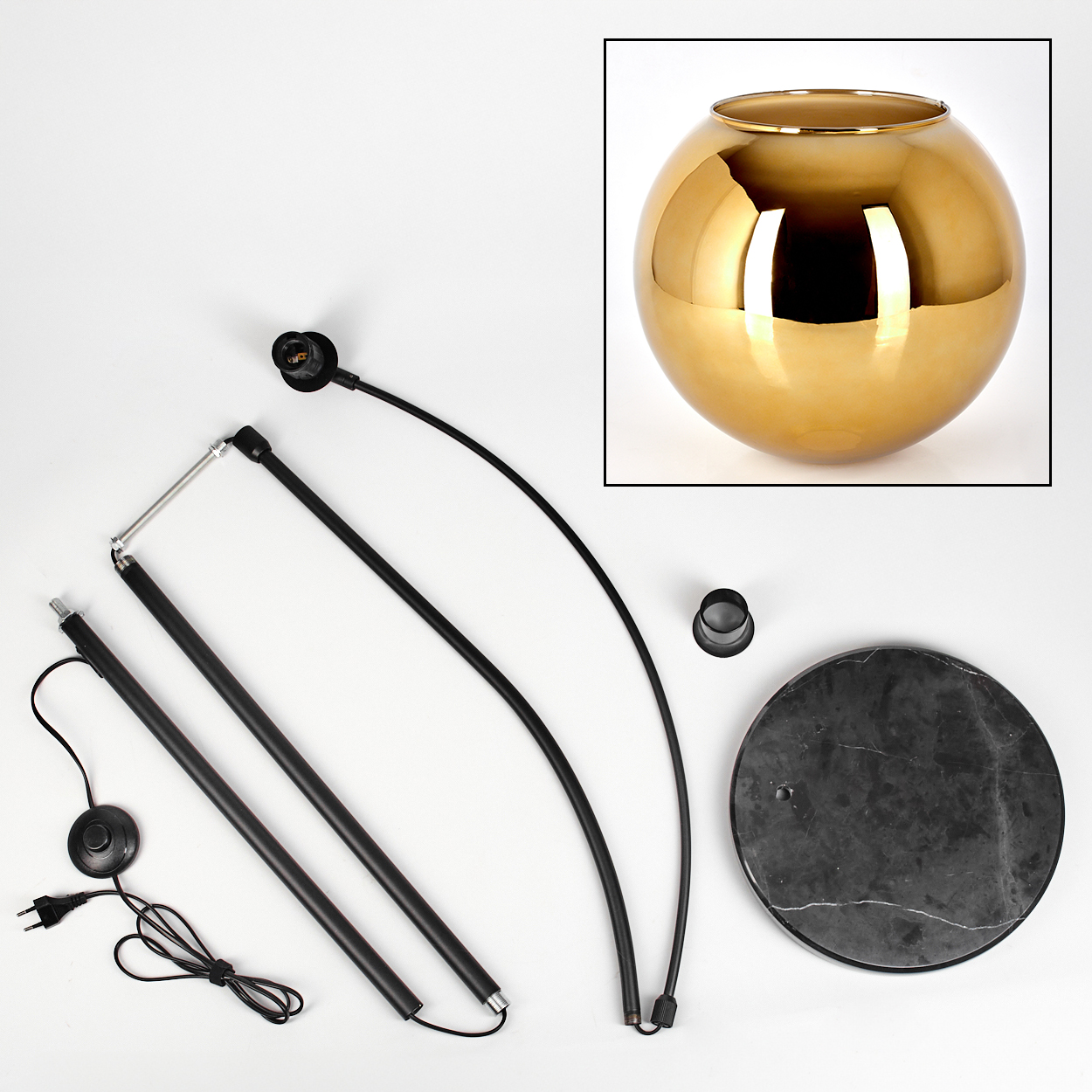 Zerlegte Lampe mit goldener Kugel, schwarzen Standkomponenten und Marmorsockel vor weißem Hintergrund.