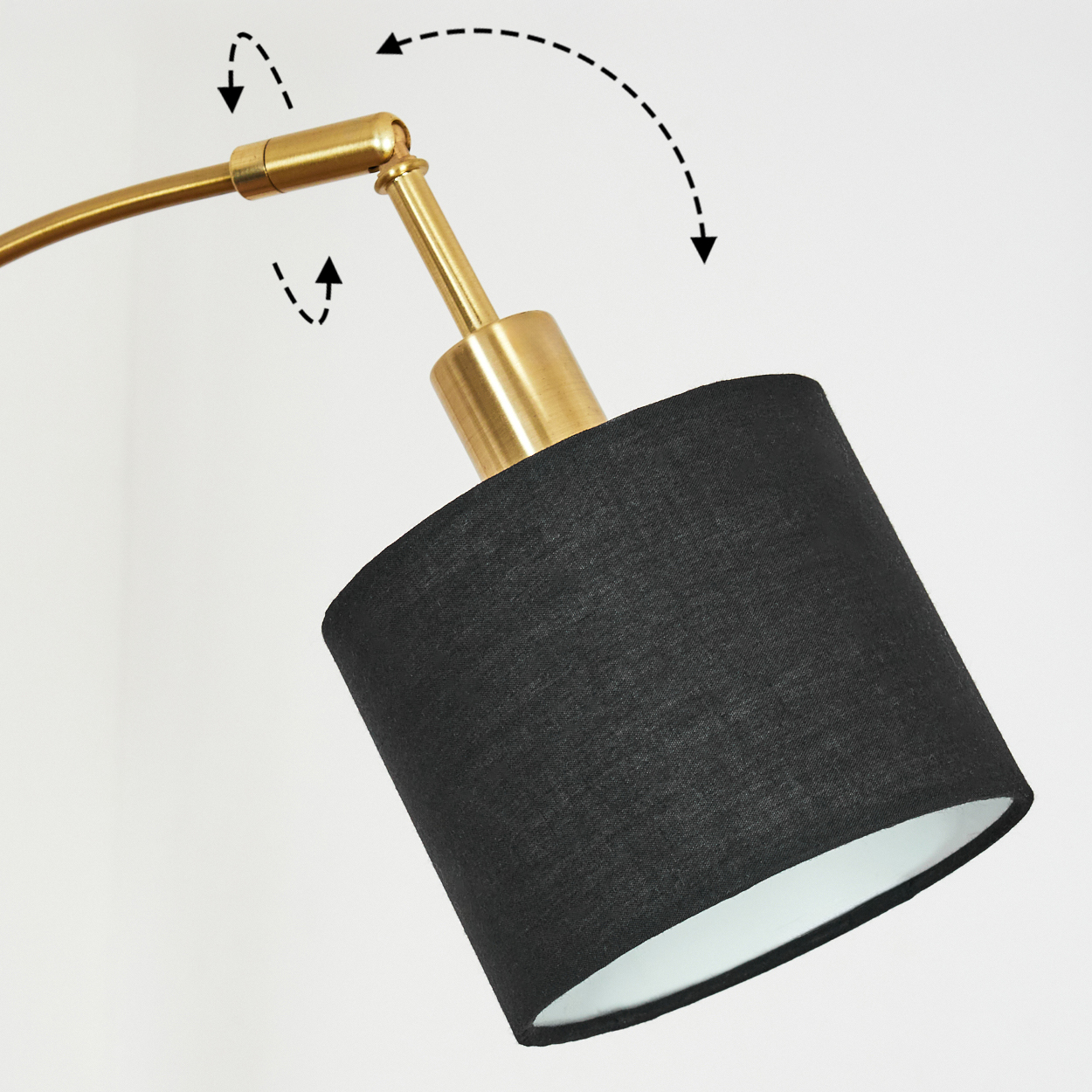 Eine moderne Lampe mit schwarzem Lampenschirm und messingfarbenem Arm. Die Lampe steht vor weißem Hintergrund.