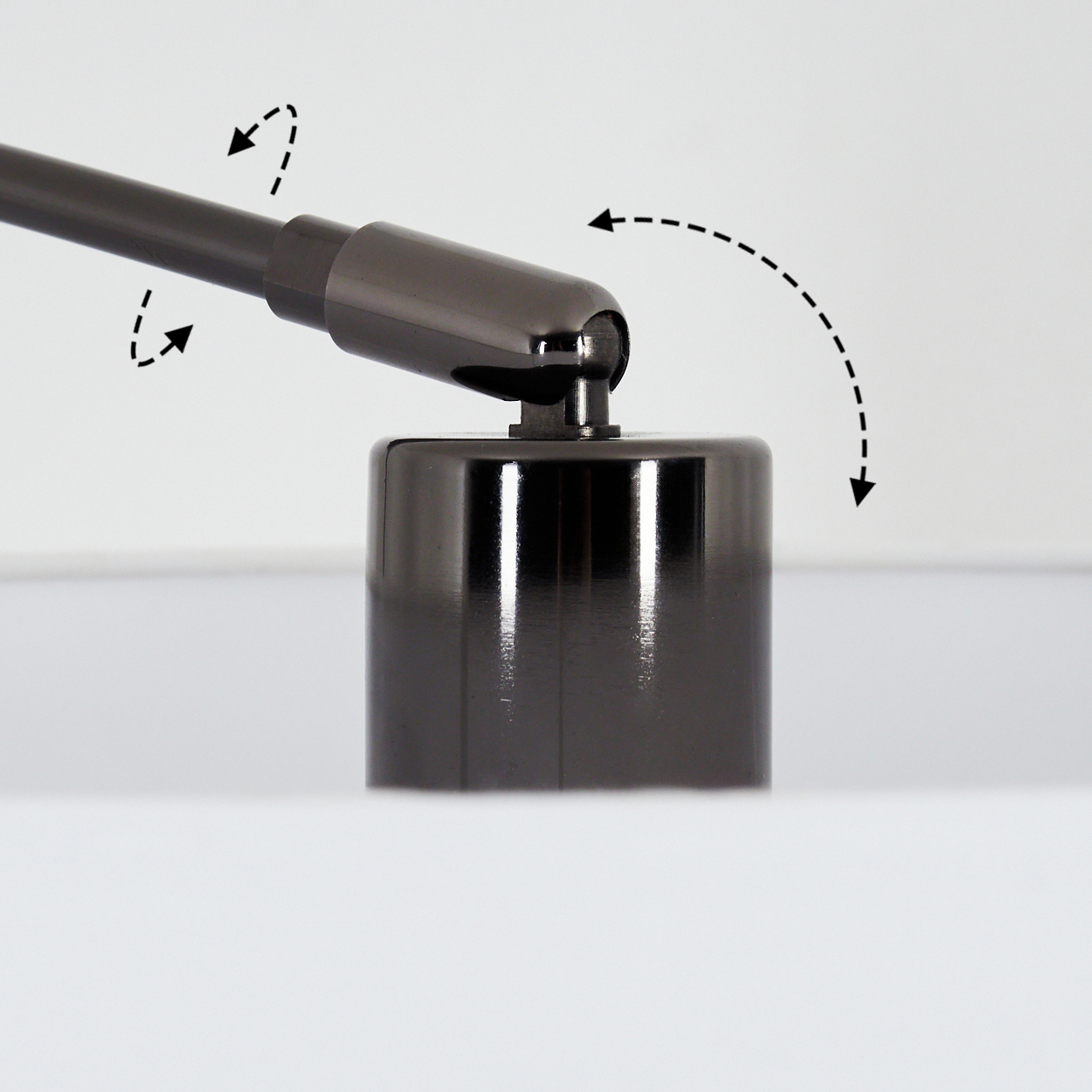 Dunkles Metall-Lampenbauteil mit Bewegungspfeilen. Die Lampe ist vor weißem Hintergrund teilweise sichtbar.