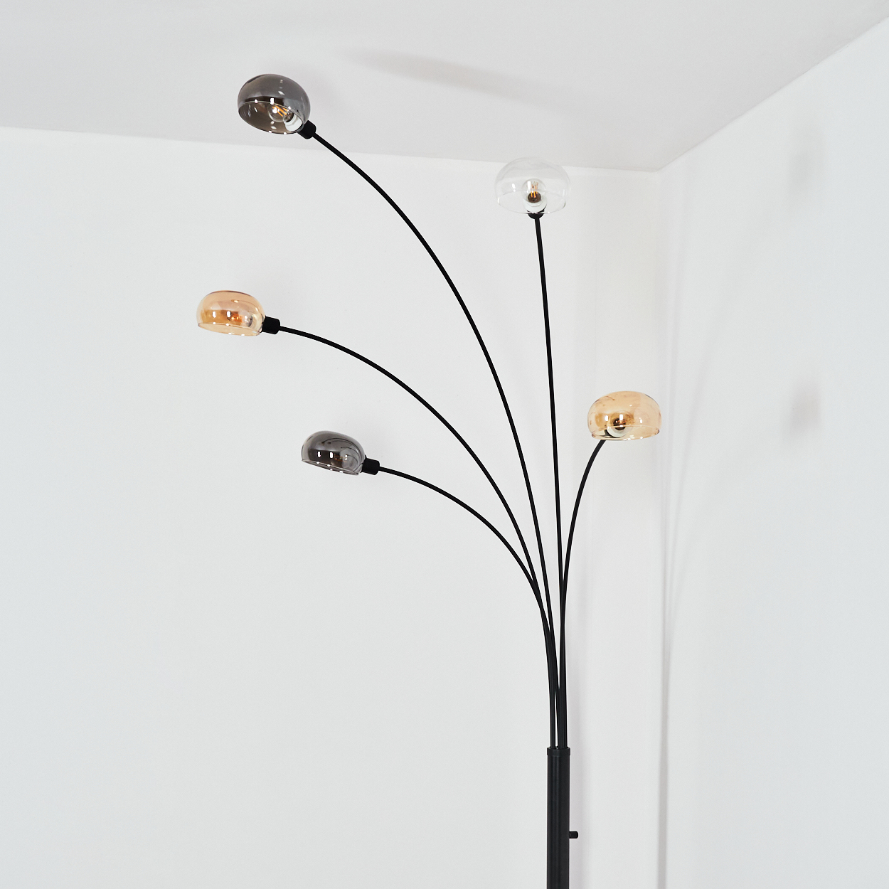 Eine moderne Stehlampe mit fünf gebogenen Armen, die jeweils eine kugelförmige Leuchte halten. Die Kugeln sind verschieden transparent.