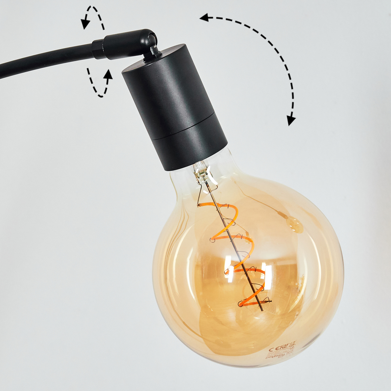 Nahaufnahme einer schwarzen Lampe mit einer großen, warm getönten Glühbirne. Die Birne ist rund mit einem spiralförmigen Glühfaden.