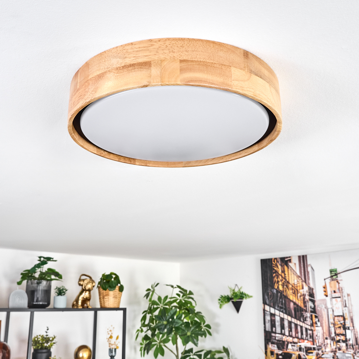 Eine Holzdeckenlampe mit weißer Lichtfläche ist zentriert. Darunter sind Pflanzen, ein goldener Hund und ein Stadtbild zu sehen.