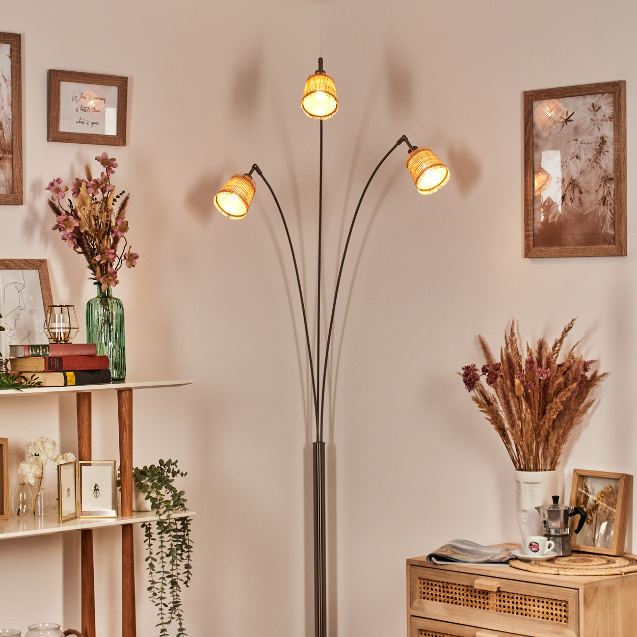 Ein Raum mit Stehlampe, Bücherregalen und Holzschrank. Es gibt auch Bilderrahmen, Blumen und Dekorationen.