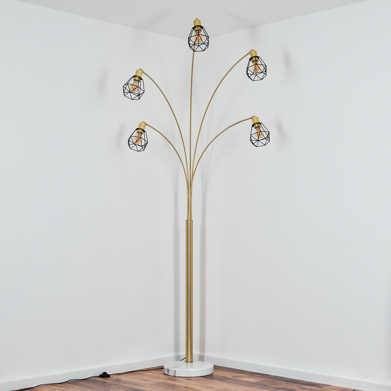Eine goldene Stehlampe mit sechs Lichtern, schwarzen Käfigen und einem Marmorsockel steht in einer weißen Ecke. Holzfußboden.