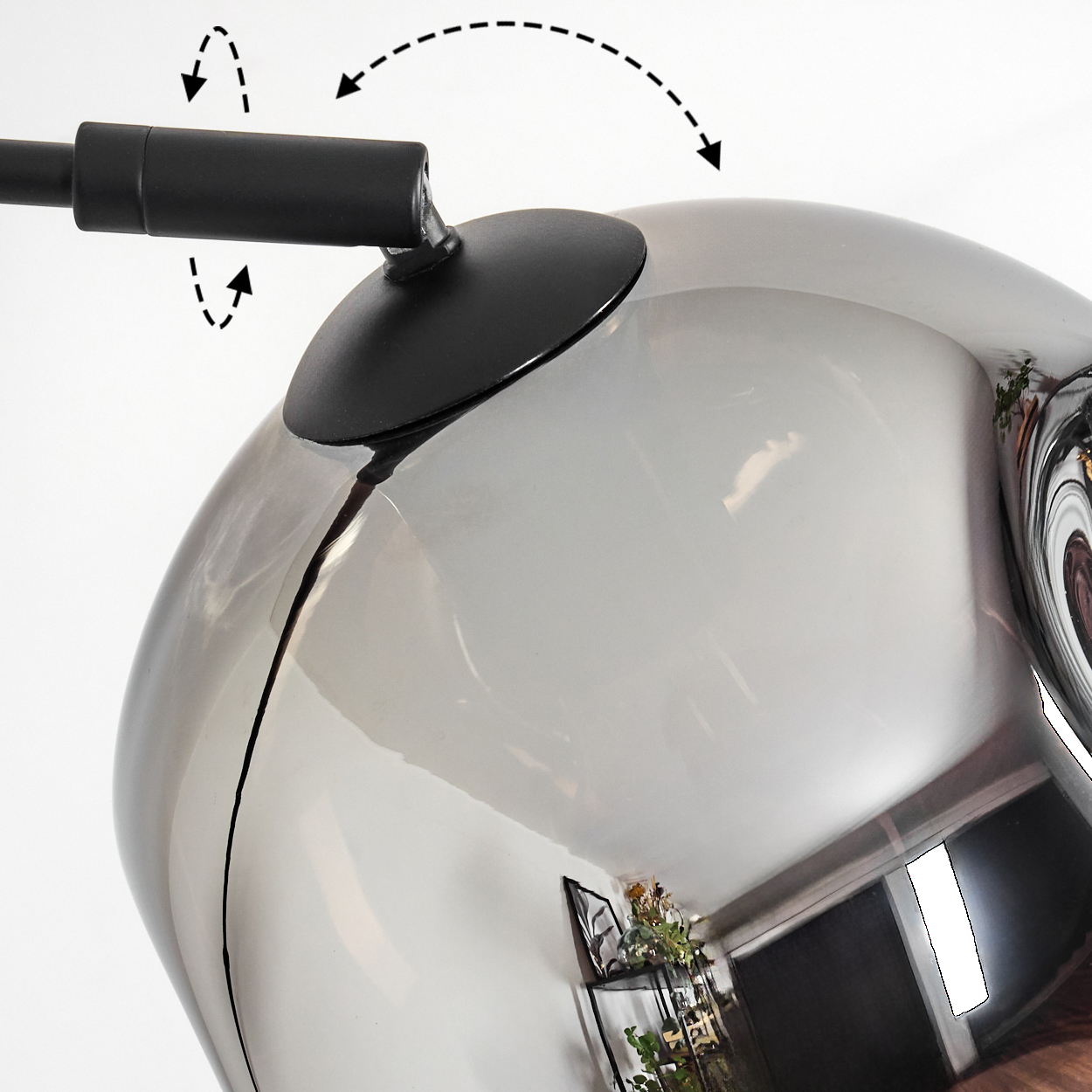 Nahaufnahme einer modernen Lampe. Ein schwarzer Arm verbindet sich mit einem reflektierenden, grauen Globus. Pfeile zeigen die Einstellung an. Der Globus spiegelt einen Raum wider.
