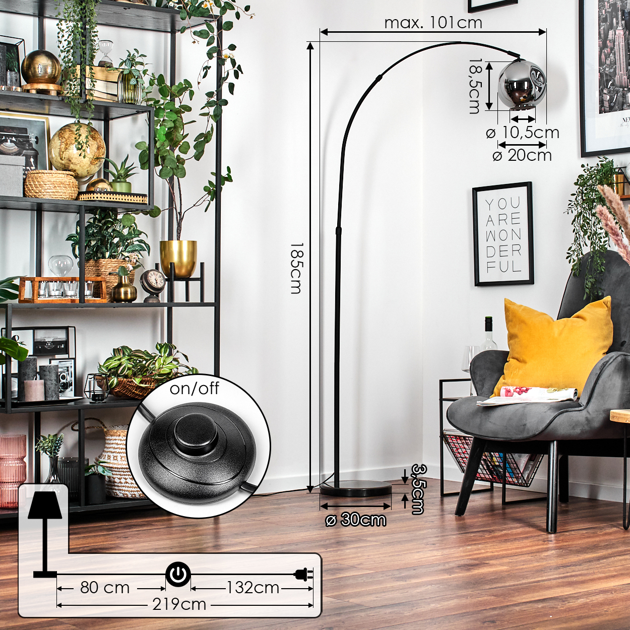 Ein modernes Wohnzimmer mit einer schwarzen Bogen-Stehlampe, einem grauen Sessel, einem gelben Kissen und einem Deko-Regal mit Pflanzen.