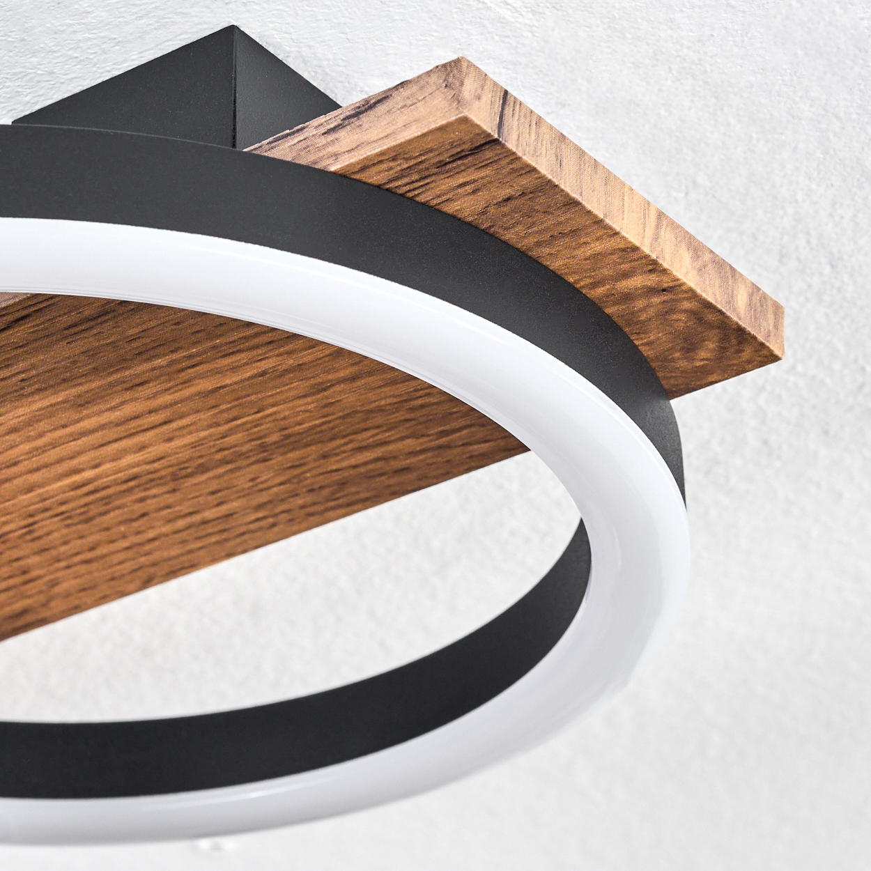 Eine moderne Deckenleuchte mit Holzregal und weißem, ringförmigem Licht. Ein schwarzer Ring ist ebenfalls sichtbar.