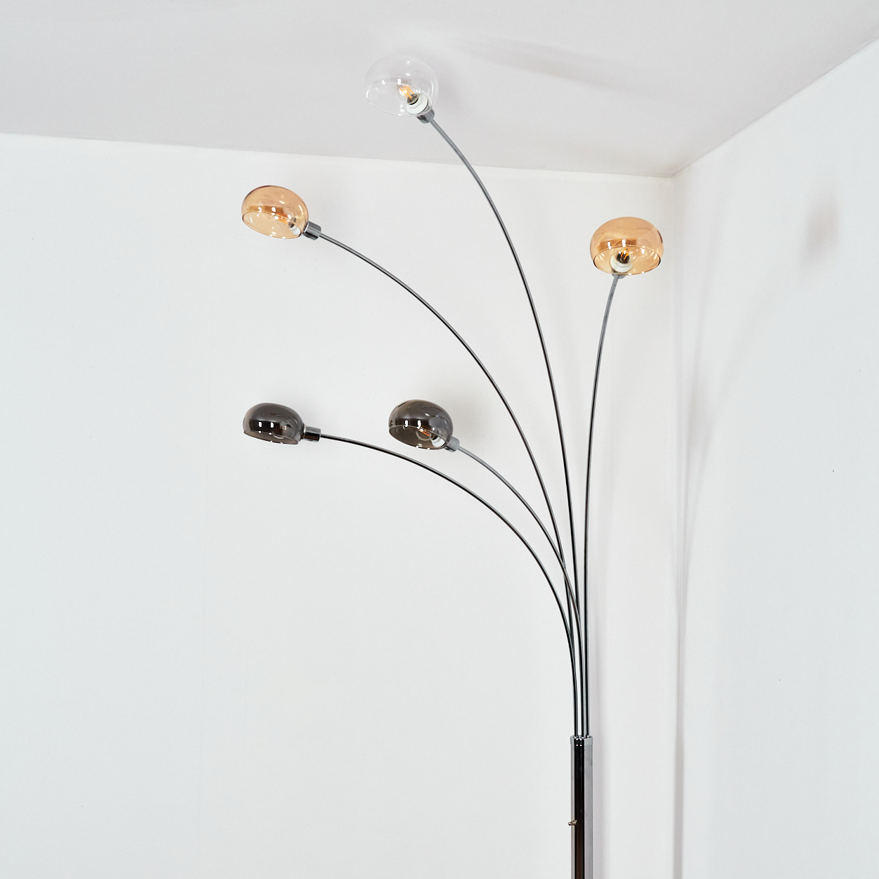Eine moderne Stehlampe mit fünf gebogenen Armen, die jeweils eine kugelförmige Leuchte halten. Die Farben variieren von klar bis bernsteinfarben.