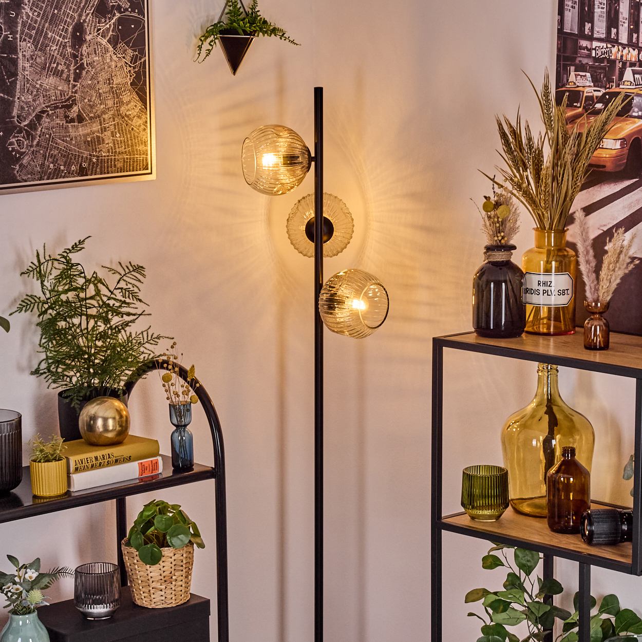Eine Zimmerecke mit Stehlampe, Regalen mit Dekoration, Pflanzen und einer Karte. Die Szene hat ein warmes, einladendes Ambiente.