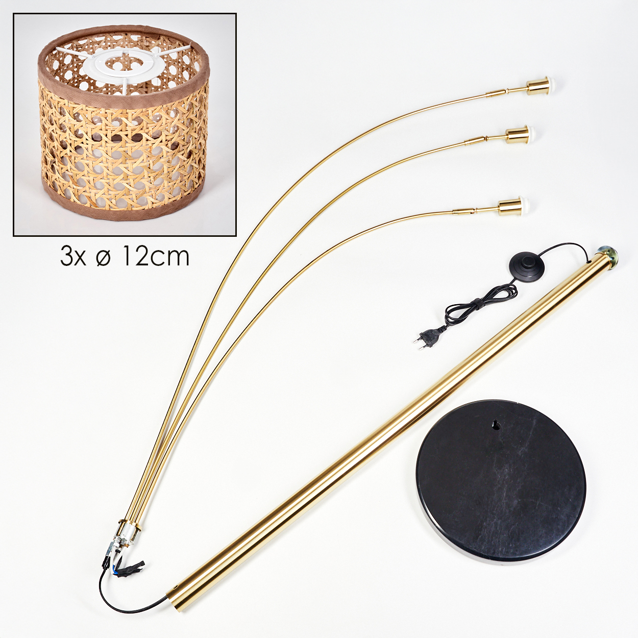 Eine zerlegte Stehlampe mit drei gebogenen Armen, einem Schirm, einem Sockel und einem Netzkabel. Der Schirm ist aus Korbgeflecht. Teile sind golden.