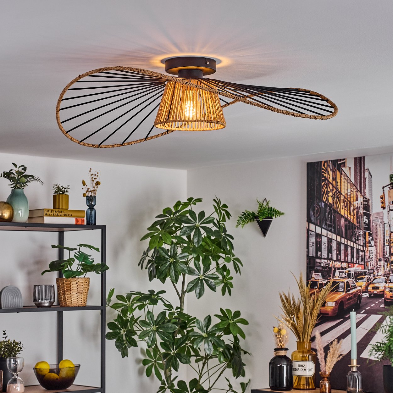 Dekorative Deckenlampe mit gewebtem Lampenschirm, umgeben von Pflanzen und einem New York City-Bild an der Wand.