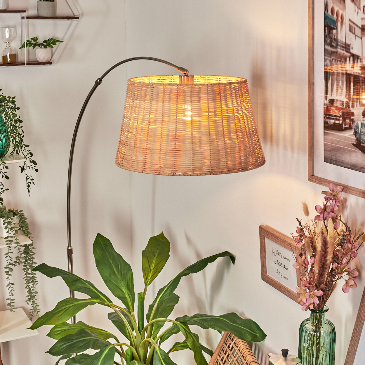 Eine gewebte Lampe beleuchtet einen Raum mit Pflanzen und einem gerahmten Bild. Eine grüne Pflanze befindet sich im Vordergrund.