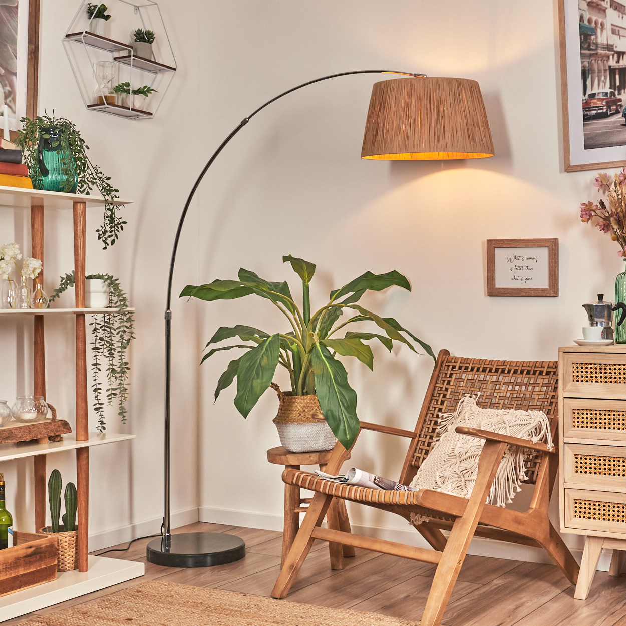 Ein Wohnzimmer mit Lesesessel, Stehlampe, Pflanzen und Regalen. Ein Holzschrank und ein Bilderrahmen sind ebenfalls sichtbar.