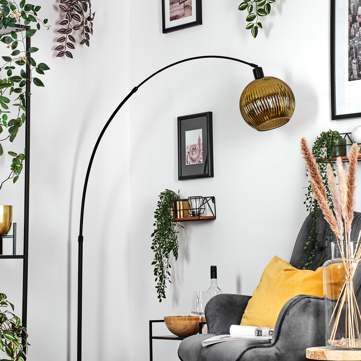 Ein modernes Wohnzimmer mit schwarzer Stehlampe, grauem Sessel mit gelbem Kissen und dekorativen Pflanzen.