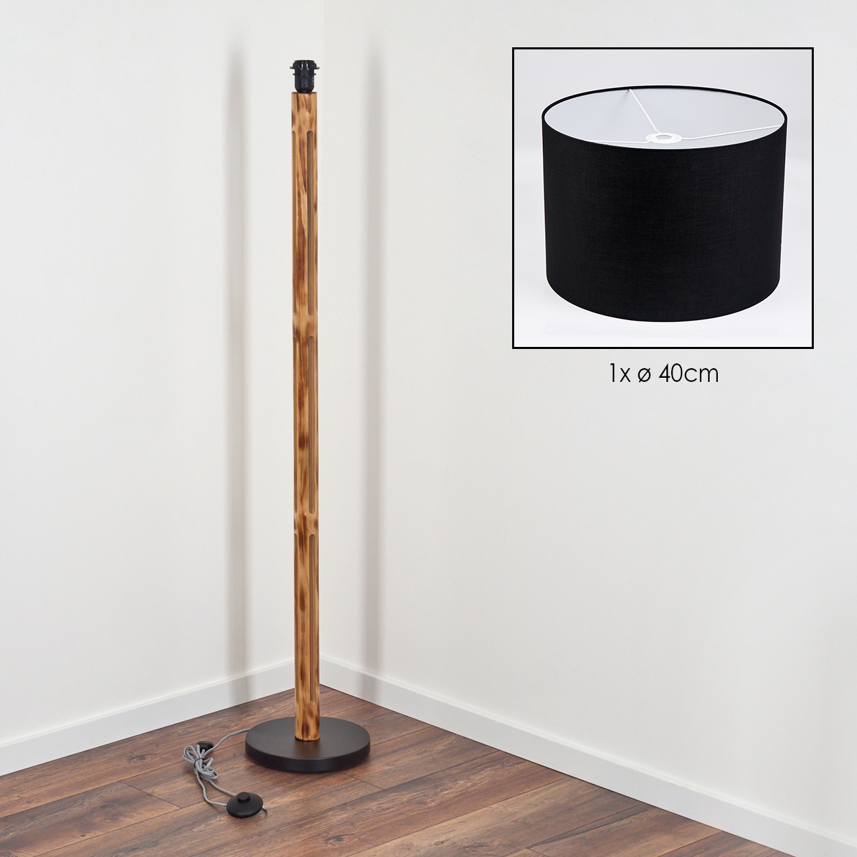 Eine Stehlampe aus Holz mit schwarzem Lampenschirm. Die Lampe steht in einer Ecke. Ein schwarzer Lampenschirm ist in einem Quadrat.