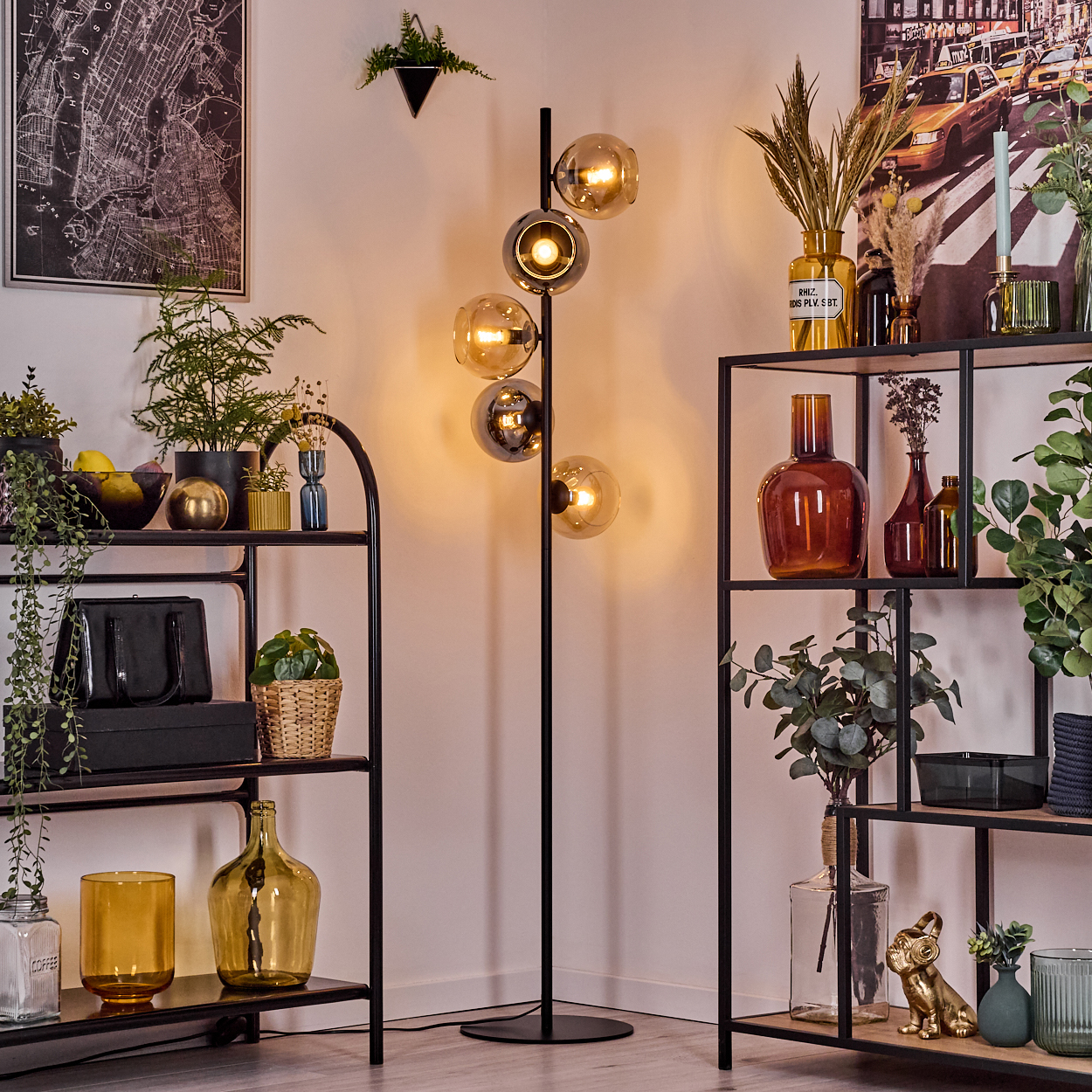 Moderne Wohnzimmerecke mit schwarzer Stehlampe, Regalen mit Pflanzen, Vasen und Dekorationsartikeln. Eine Karte und eine Stadtszene.