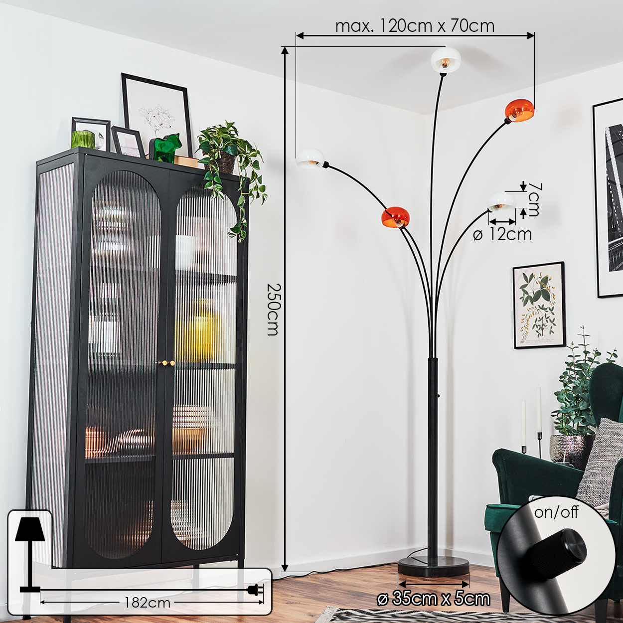 Ein Raum mit einem schwarzen Schrank und einer modernen Stehlampe. Die Lampe hat orange und weiße Kugeln. Rechts ist ein grüner Sessel.