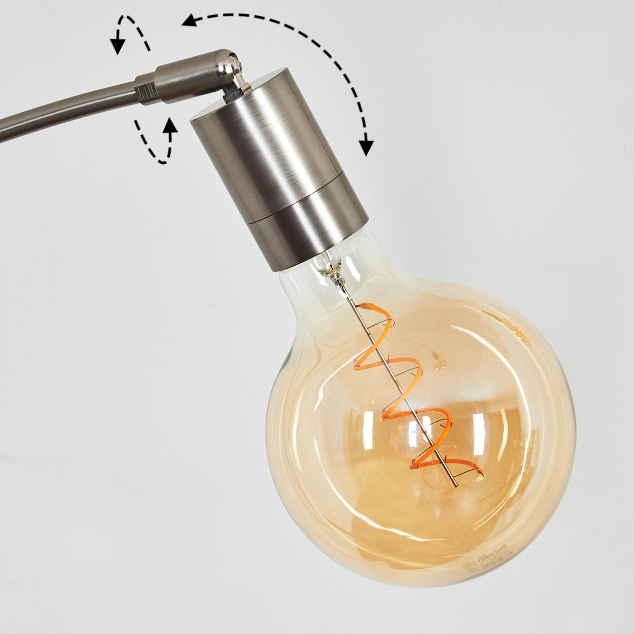 Nahaufnahme einer Lampe. Eine große, bernsteinfarbene Glühbirne ist mit einem silbernen Metallarm verbunden. Pfeile zeigen die Bewegung an.