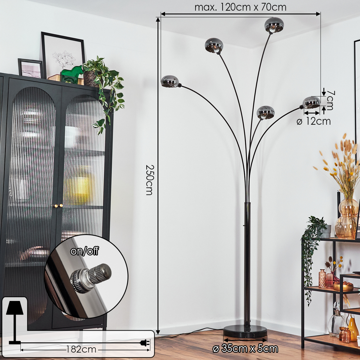 Eine schwarze Stehlampe mit fünf kugelförmigen Lichtern. Sie steht neben einem schwarzen Schrank und einem Regal mit Dekorationen.