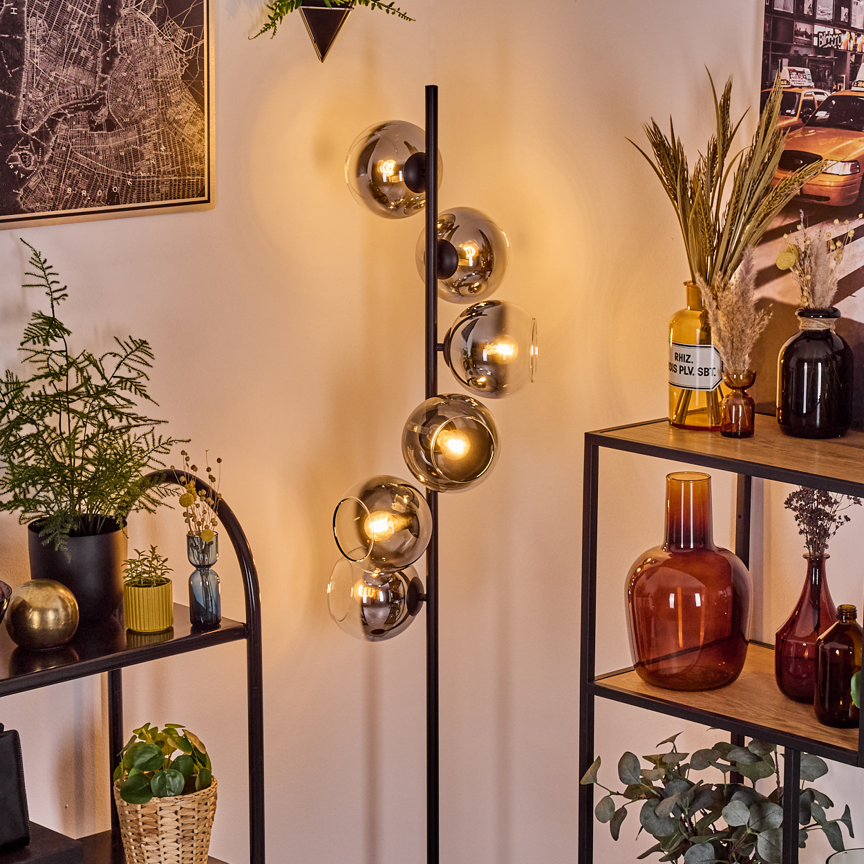 Moderne Wohnzimmerszene mit Kugellampe, Regalen, Pflanzen und dekorativen Vasen. Die Lampe wirft ein warmes Licht.