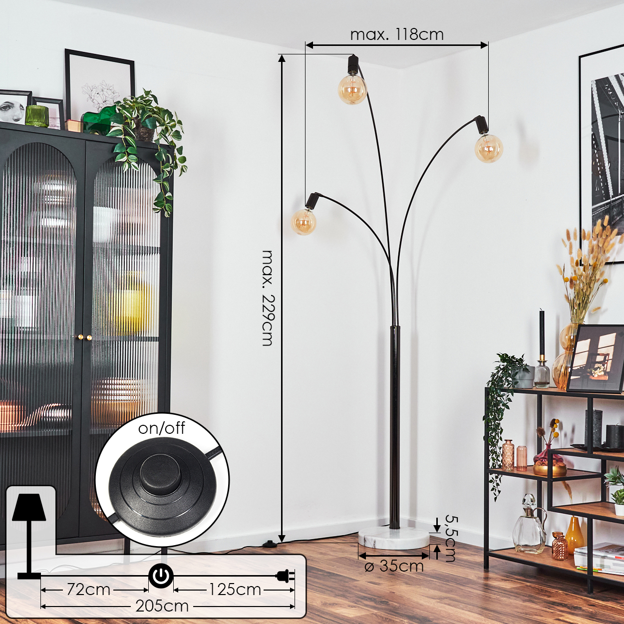 Eine schwarze Stehlampe mit drei Glühbirnen. Sie steht auf einem weißen Marmorsockel. Die Lampe steht neben einem schwarzen Schrank und einem Holzregal.