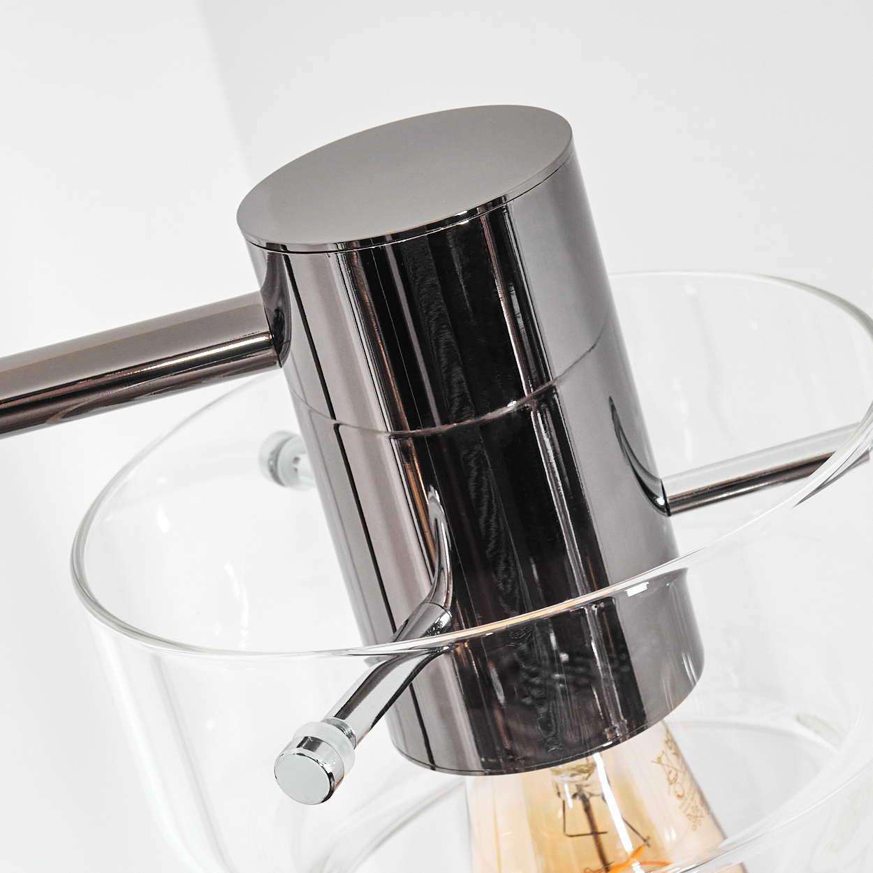 Nahaufnahme einer modernen Lampe mit Chromausführung. Die Lampe hat einen zylindrischen Körper in einer Glasschale, mit Glühbirne.