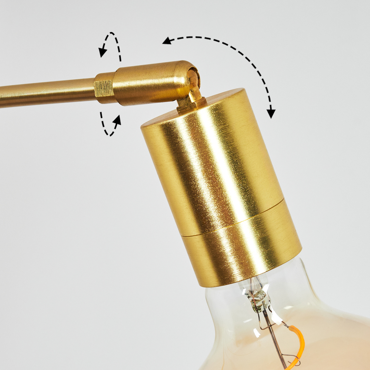 Nahaufnahme einer goldfarbenen Lampe. Der Arm der Lampe ist mit dem Lampenhalter verbunden. Pfeile zeigen verstellbare Winkel an.