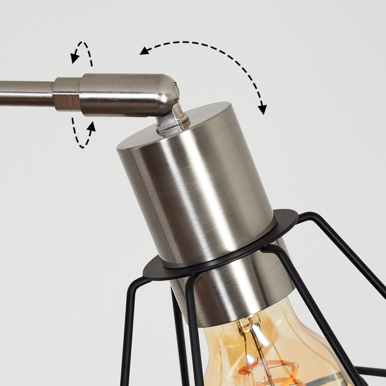Nahaufnahme einer Lampe mit Metallschirm und käfigartiger Glühbirne. Die Lampe hat Richtungspfeile, die die Verstellbarkeit anzeigen.