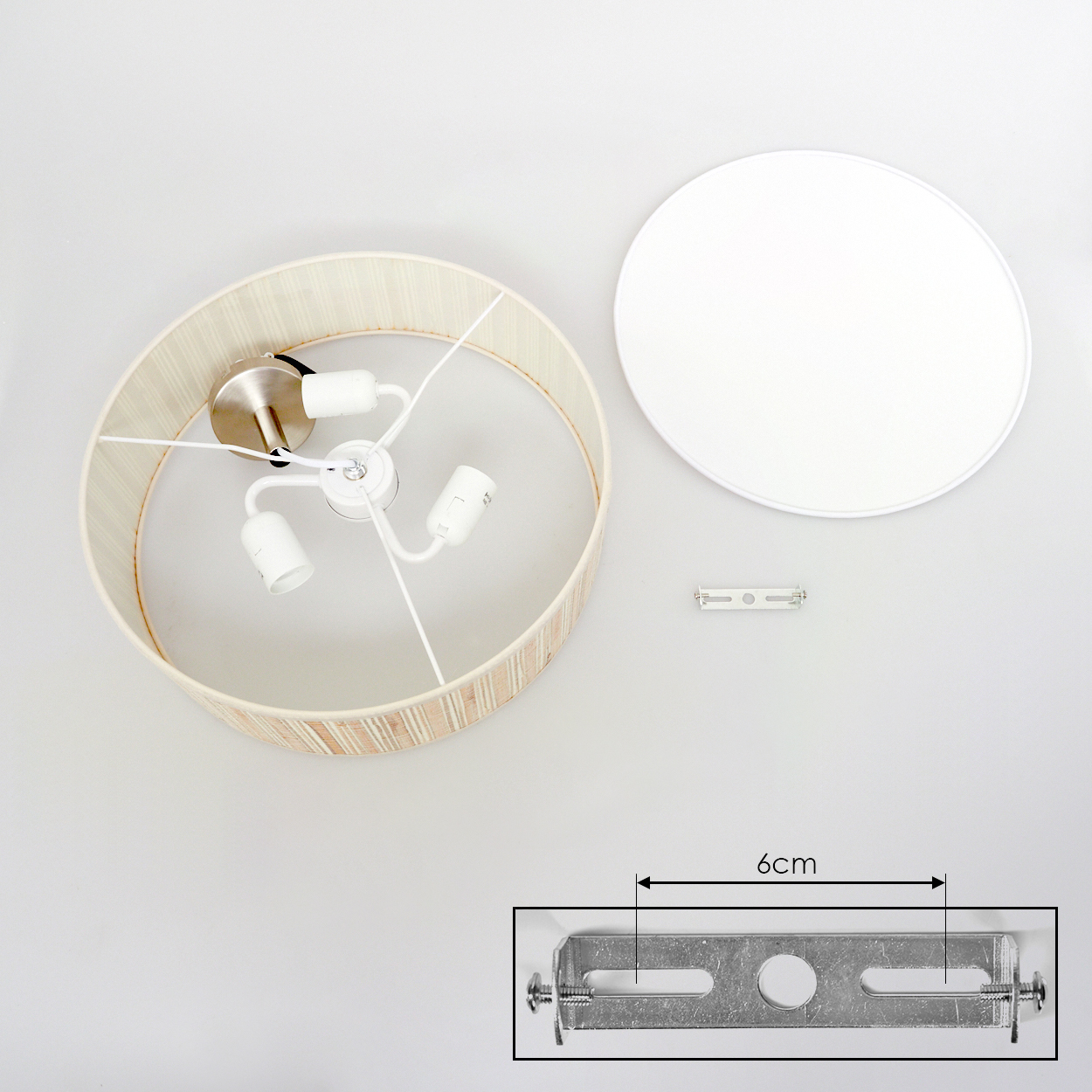 Draufsicht einer zerlegten Lampe. Lampenschirm, weiße Deckenabdeckung, Metallhalterung und Lampenfassung mit drei Glühbirnen.