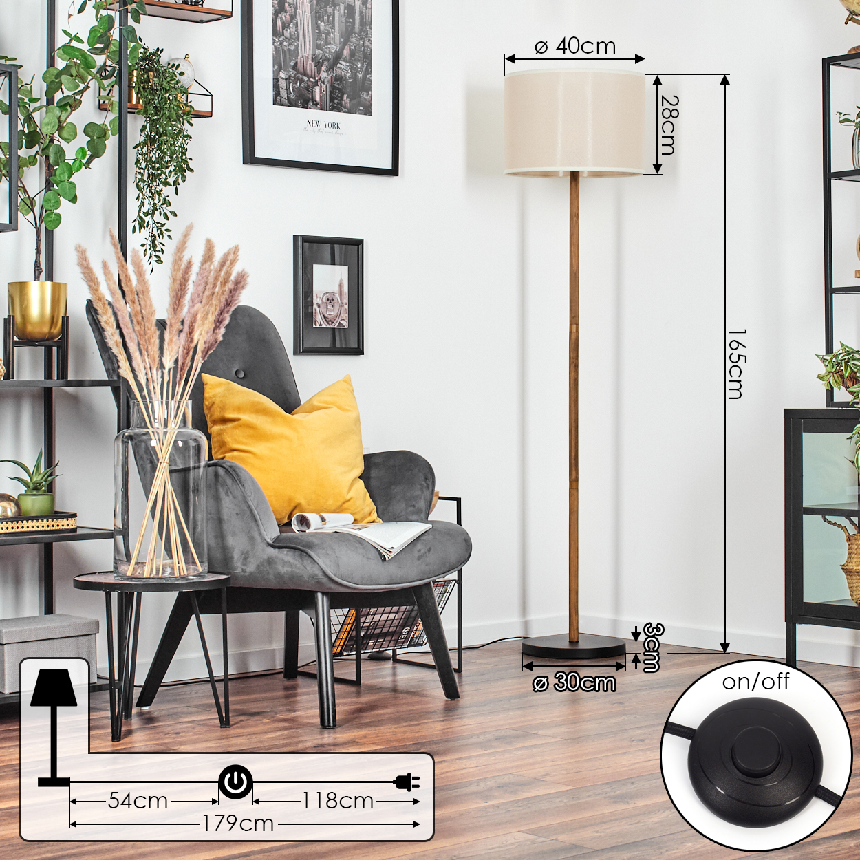 Ein Zimmer mit Stehlampe, grauem Sessel mit gelbem Kissen und dekorativen Elementen.