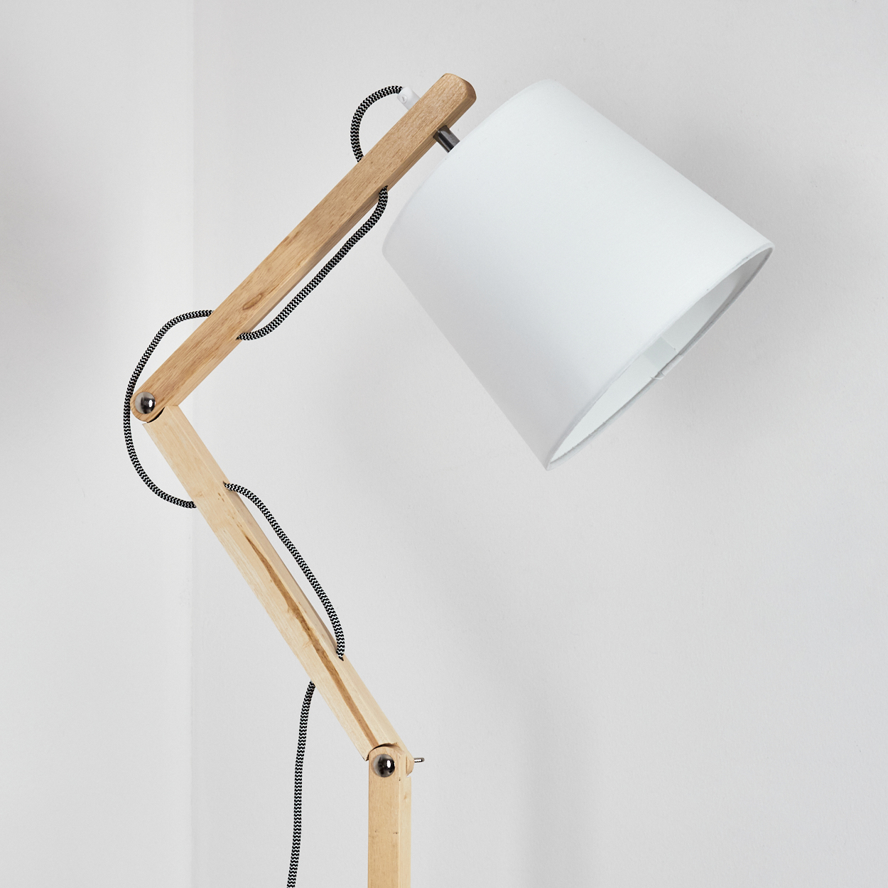 Eine moderne Stehlampe aus Holz mit weißem Lampenschirm. Die Lampe hat einen flexiblen Arm und ein schwarz-weißes Kabel. Der Hintergrund ist weiß.