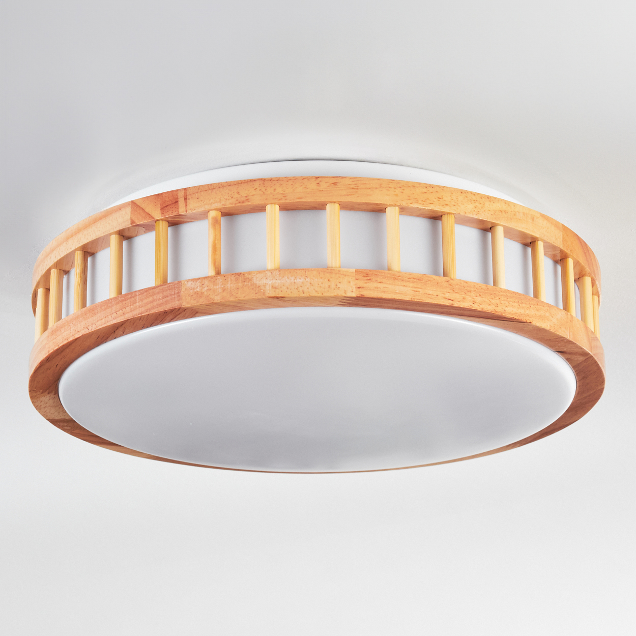 Eine runde Deckenlampe aus Holz mit weißem, kreisförmigem Licht. Der Holzrahmen hat vertikale, hellfarbige Stäbe.
