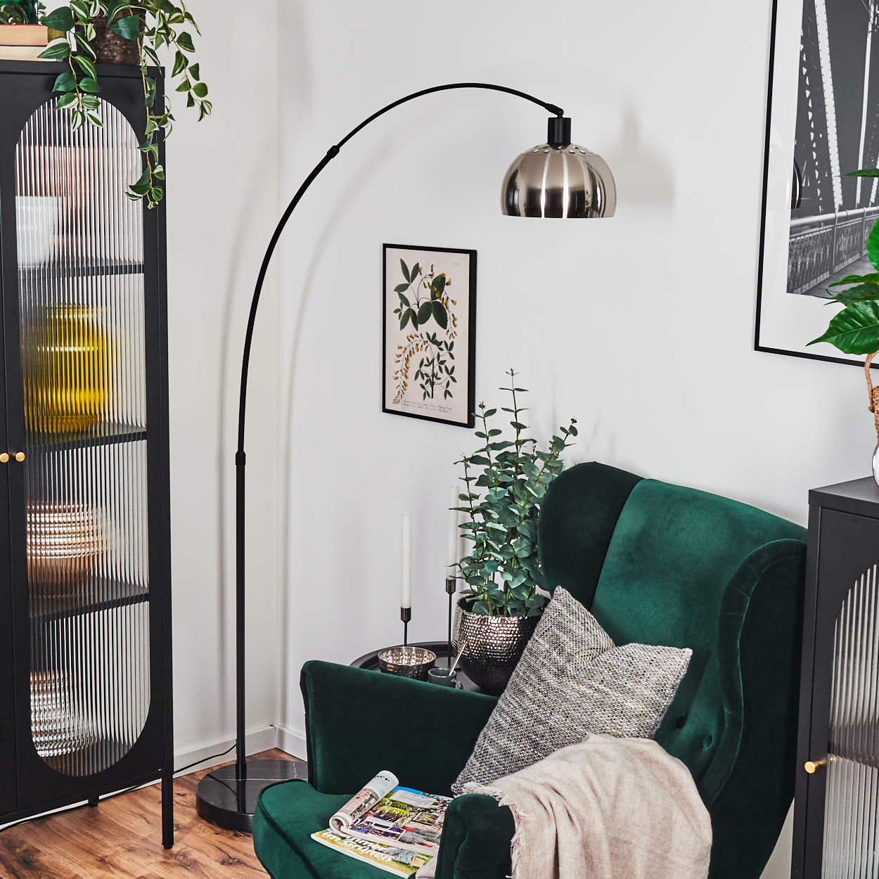 Ein grüner Sessel mit Kissen, Lampe, Schrank und Pflanzen. Zeitschrift auf dem Stuhl. Kunstwerk an der Wand.